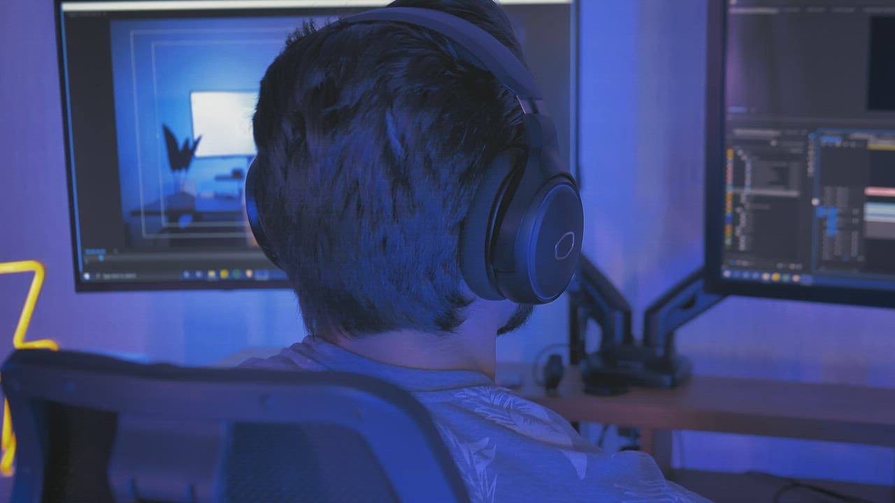 Creator editing a video on a multi-monitor workstation